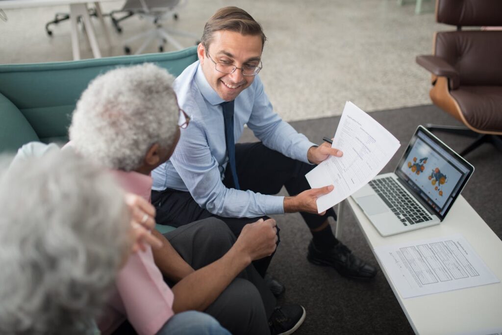 Mastering the First Impression: Your intriguing post title goes here Financial advisor discussing documents with senior clients in an office setting, showcasing a collaborative consulting session.